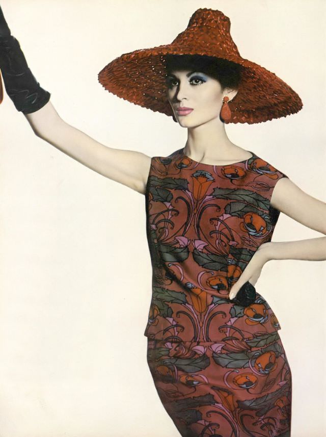 #25 Isabella Albonico in boldly colored plum-red and blue print two-piece dress on Liberty of London silk by Mollie Parnis, red straw pagoda hat by Sally Victor, earrings by Hattie Carnegie, April 1, 1961
