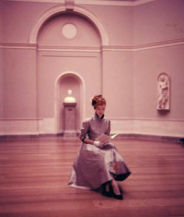 #7 Sheila Kilgore wears a Princess coat-dress of checked stiff, ridged silk lined in red taffeta with jeweled buttons and half belt in back by Mollie Parnis, Washington D.C., February 1952