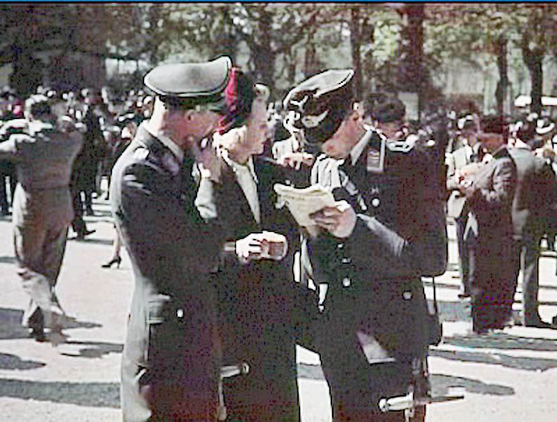 #13 Officers from the Wehrmacht chat with a Parisian woman.