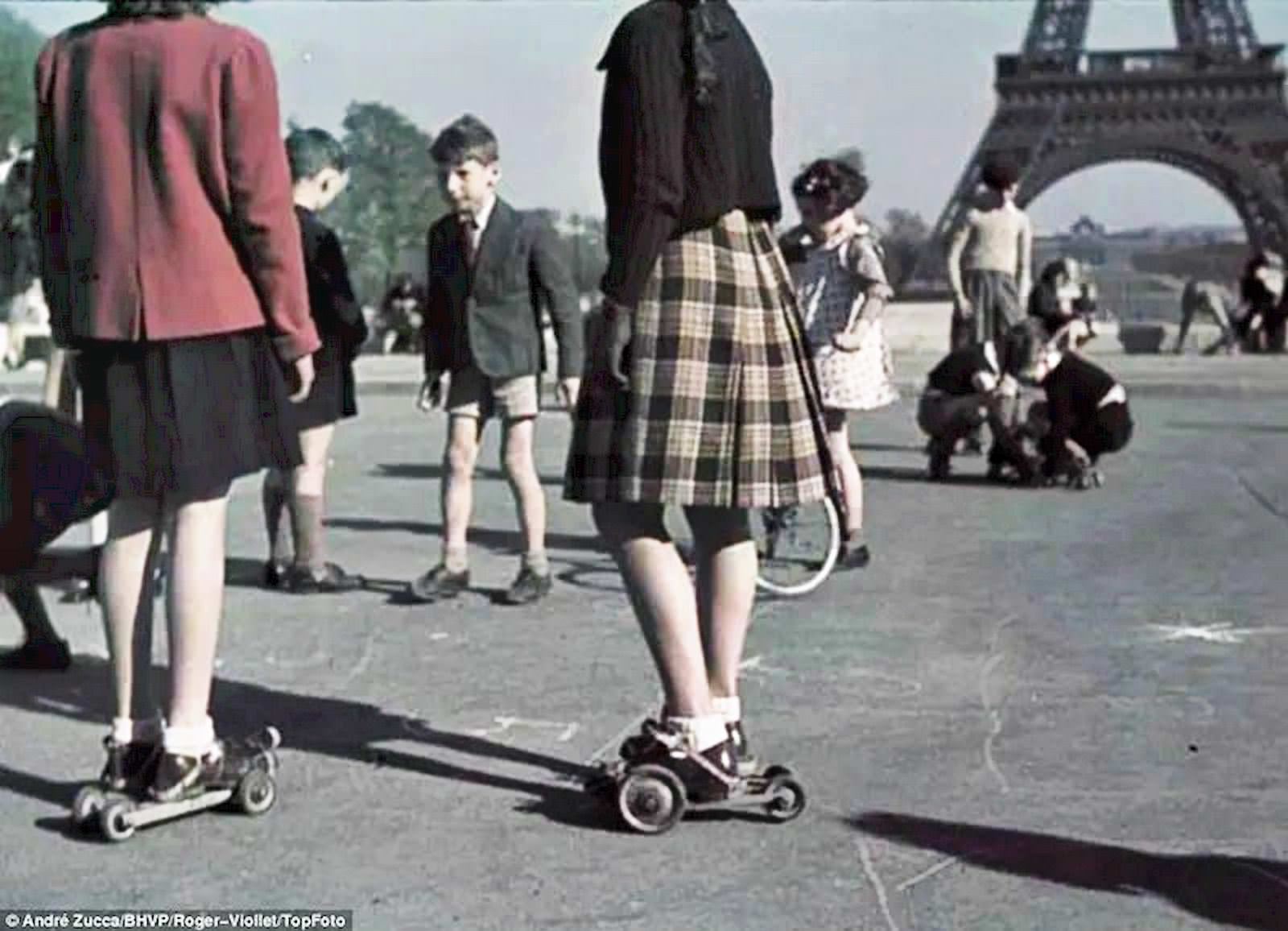 #37 Girls and boys play in what appear to be the early forerunners of rollerskates against the backdrop of the Eiffel Tower on central Paris’s Champ de Mars.