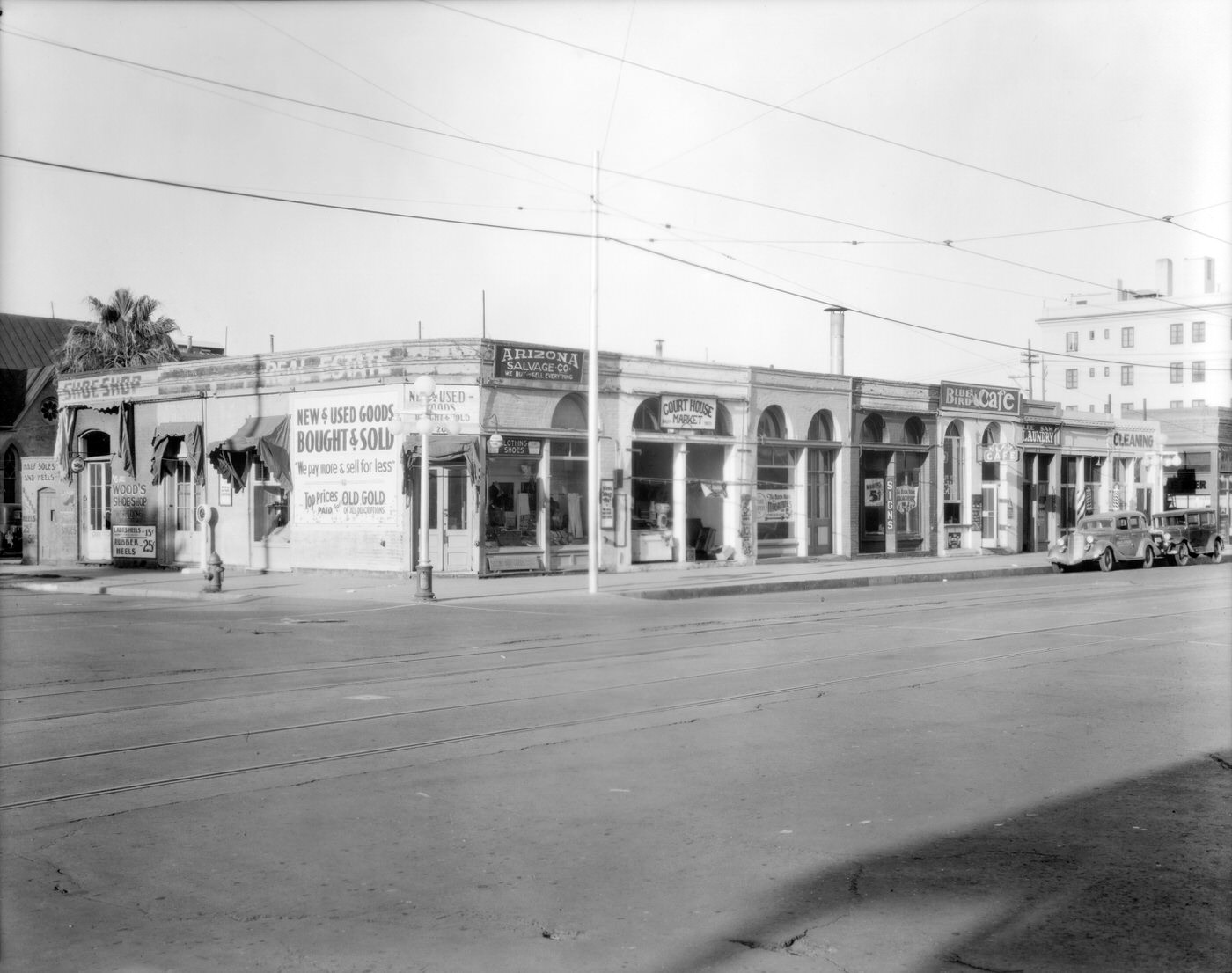 #61 Southwest Corner of Second Ave. and Washington St., 1930s. Arizona Salvage Co., the Court House Market, the Blue Bird Café, and Wood’s Shoe Shop are visible.