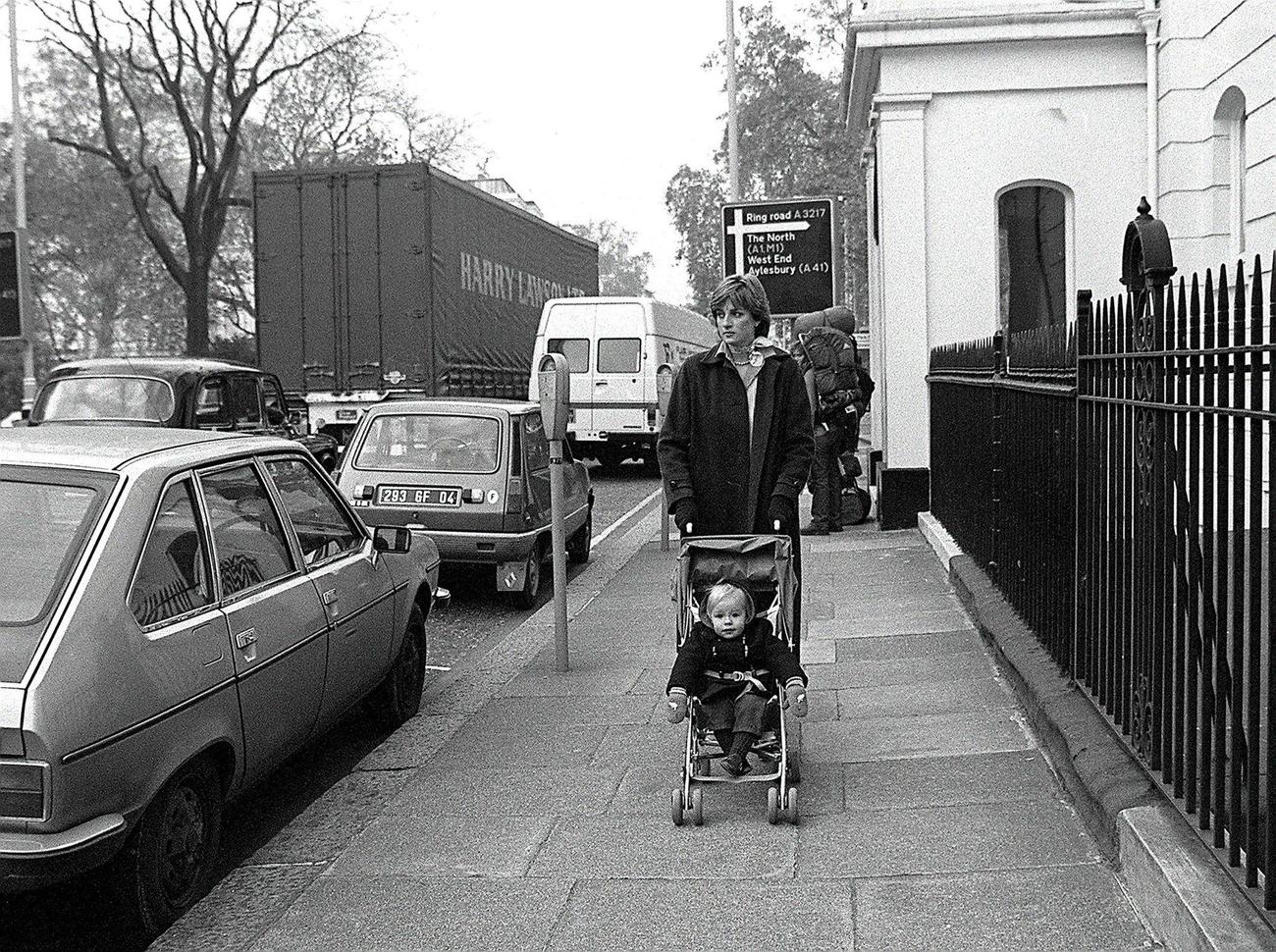 #17 Lady Diana Spencer takes her young charge Patrick Robinson for his daily outing in the Eaton Square district of London during her time as a nanny, November 1980.