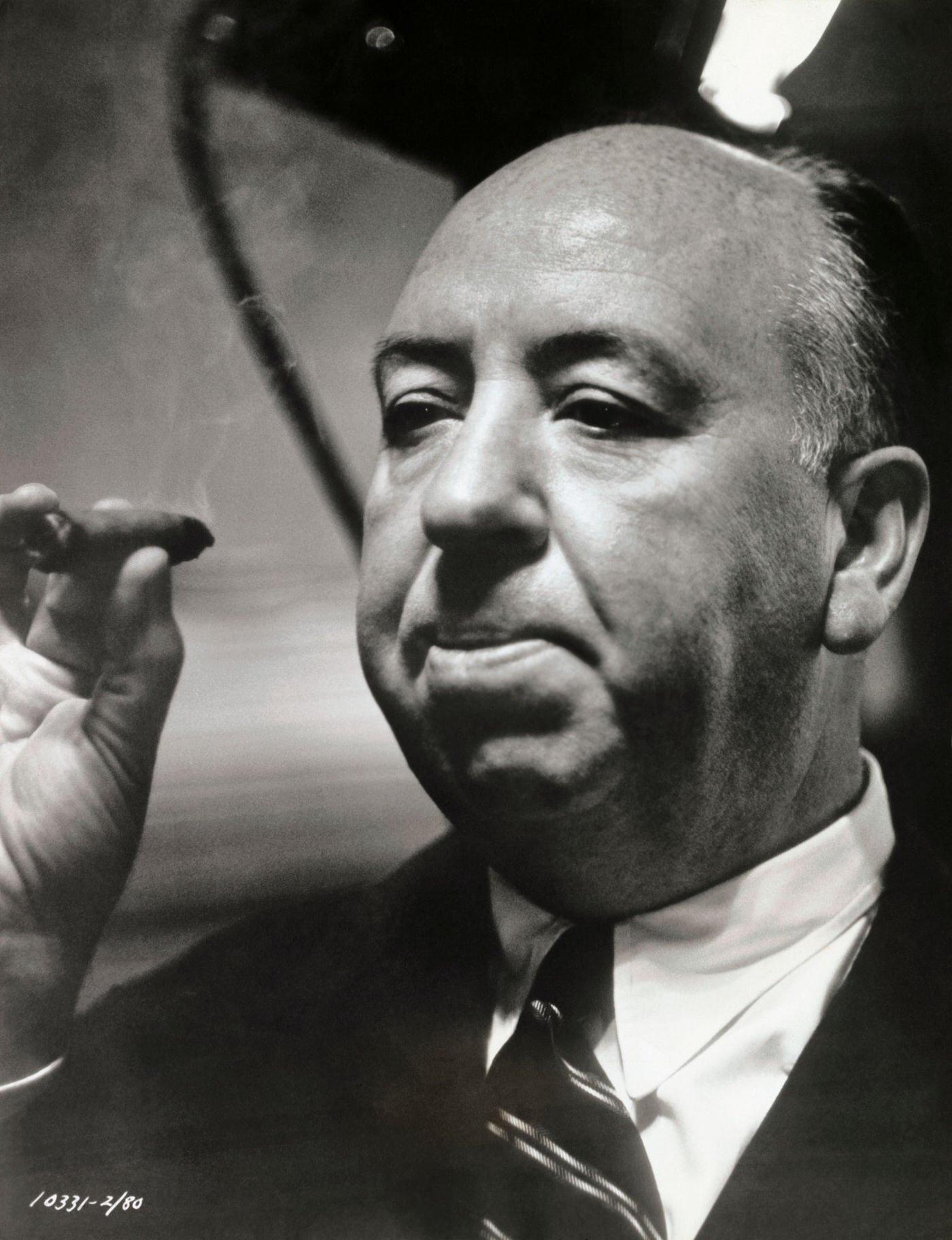 Cameraman snaps an informal shot of Alfred Hitchcock, producer-director of Paramount’s Rear Window, which stars James Stewart, Grace Kelly, and Wendell Corey.