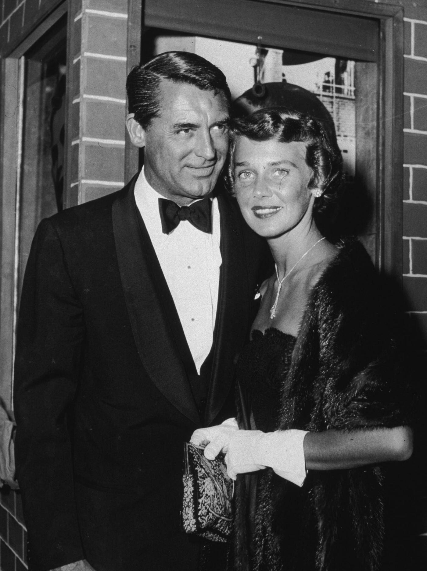 Cary Grant and his third wife, Betsy Drake, pose outside a theater while attending the premiere of ‘Rear Window,’