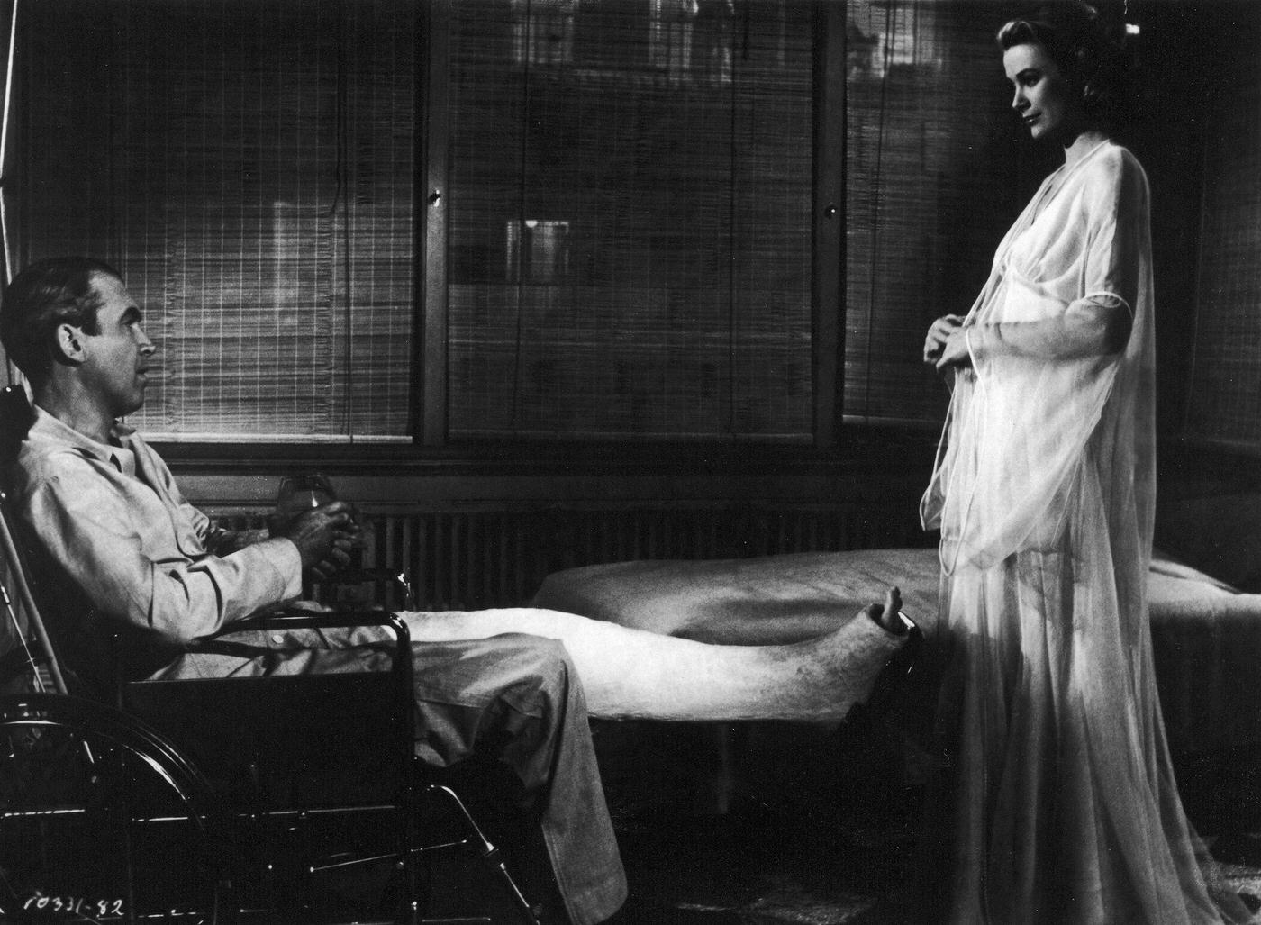 Grace Kelly models a nightgown for actor James Stewart who sits in Rear Window,’ 1954.