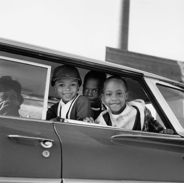 #17 Michael Willis, Harry Williams and Dwania Kyles sit in the back of a car during the first day of Memphis school integration, 1961.