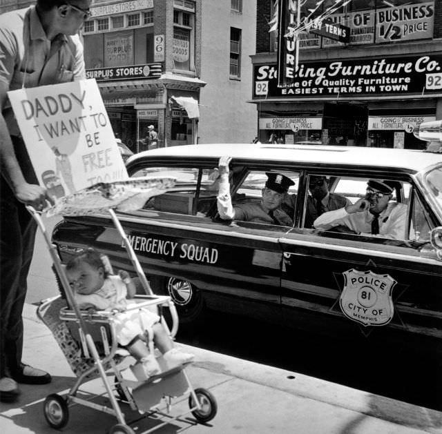 #4 William Edwin Jones pushes daughter Renee Andrewnetta Jones (8 months old) during protest, Main Street, Memphis, Tennessee, 1950s.