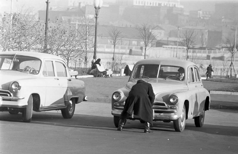 #63 A traffic policeman preparing to open the front trunk of a car.