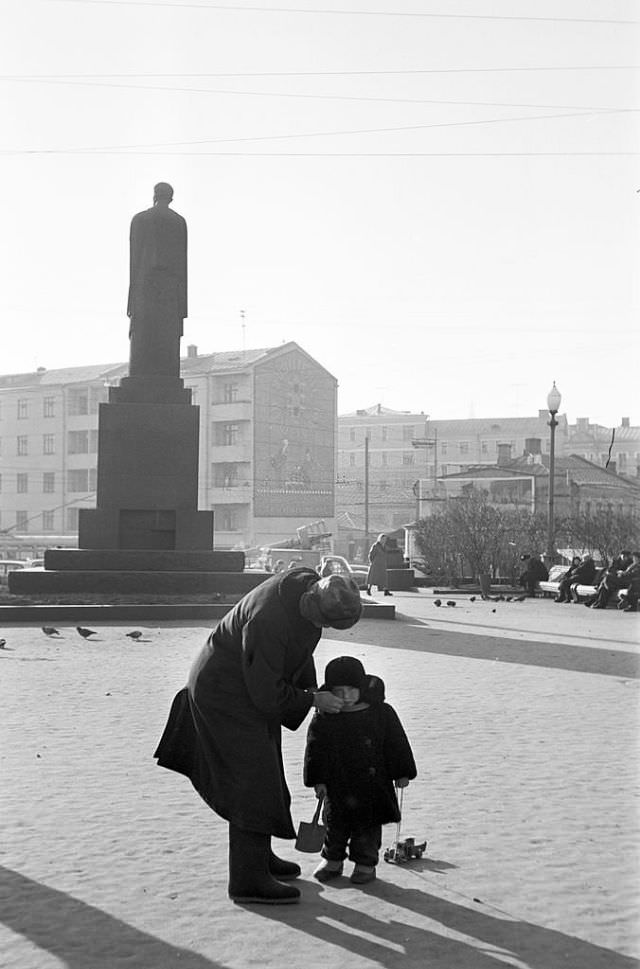#68 A man wiping a child’s face on Pushkin Square.