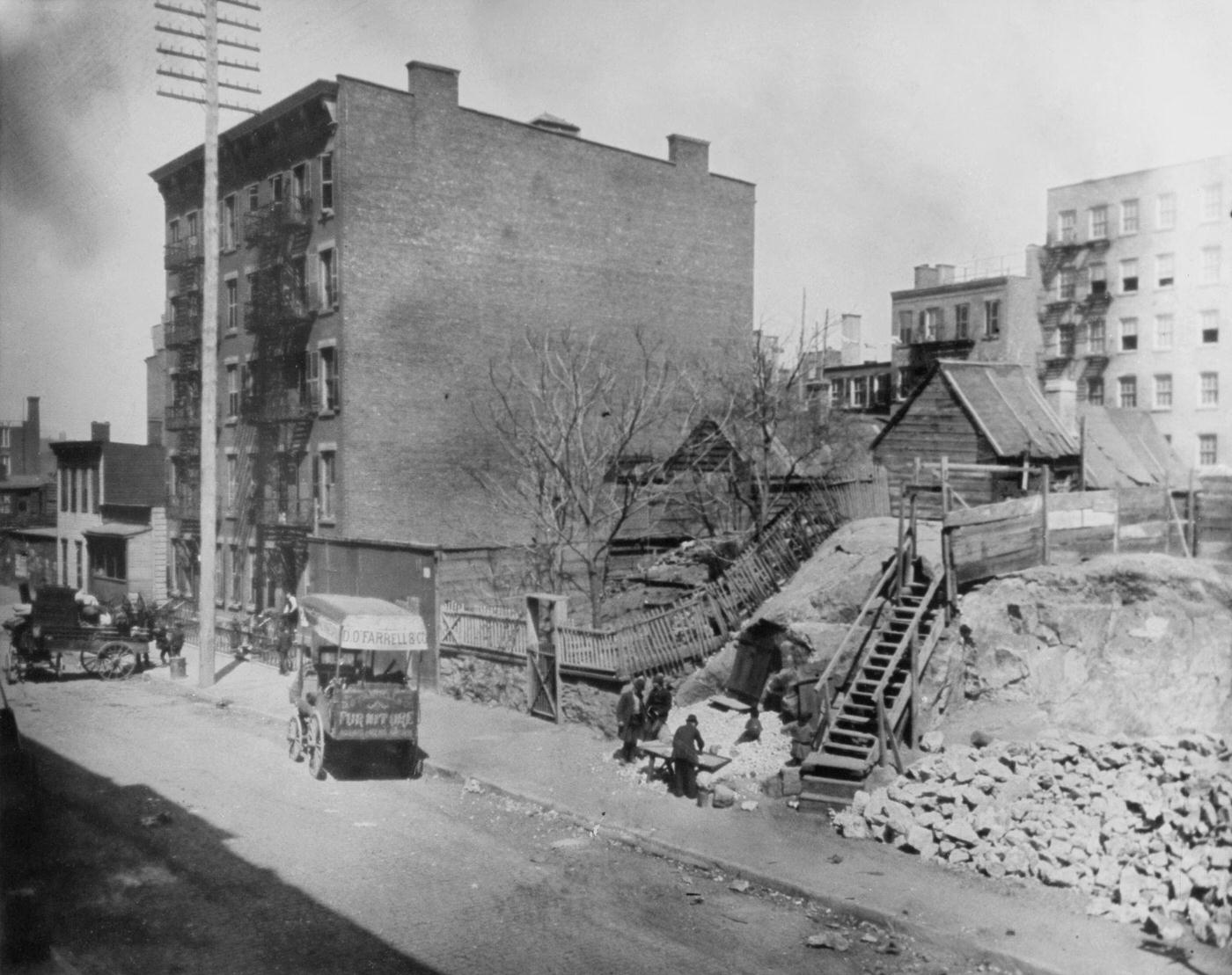#52 Carts parked along the sidewalk with a small wooden shed atop a mound of earth