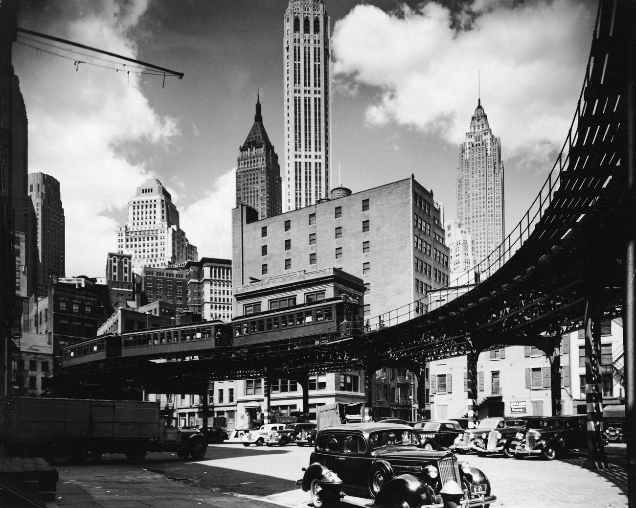 Skyline view of Manhattan’s financial district that shows an elevated train line and, at the right, 1930s