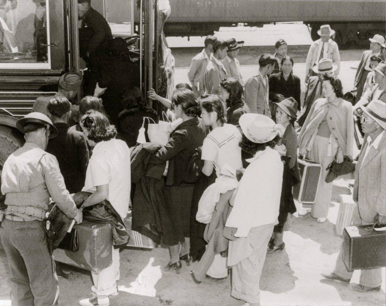 Lone Pine, Calif., May 1942 – a group arriving by train from Elk Grove, and boarding a bus for Manzanar, a War relocation authority center where evacuees of Japanese ancestry from certain West Coast, 1942