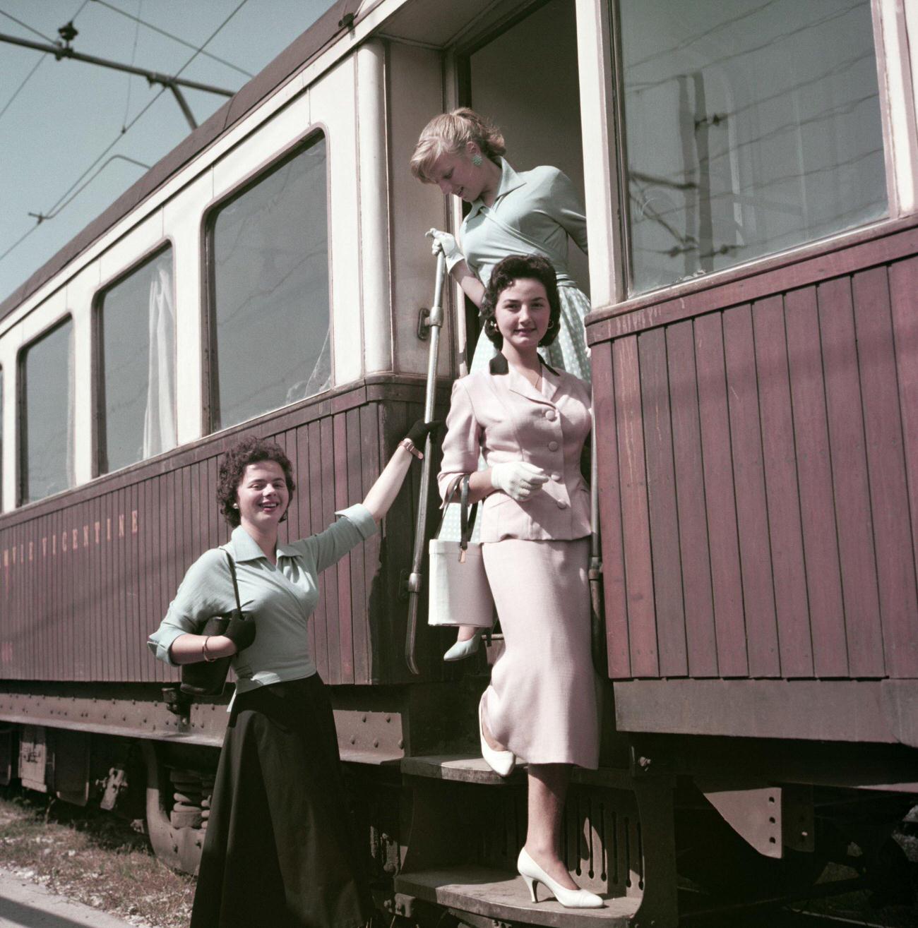 #26 Three women getting off the train at the station. Italy, 1955