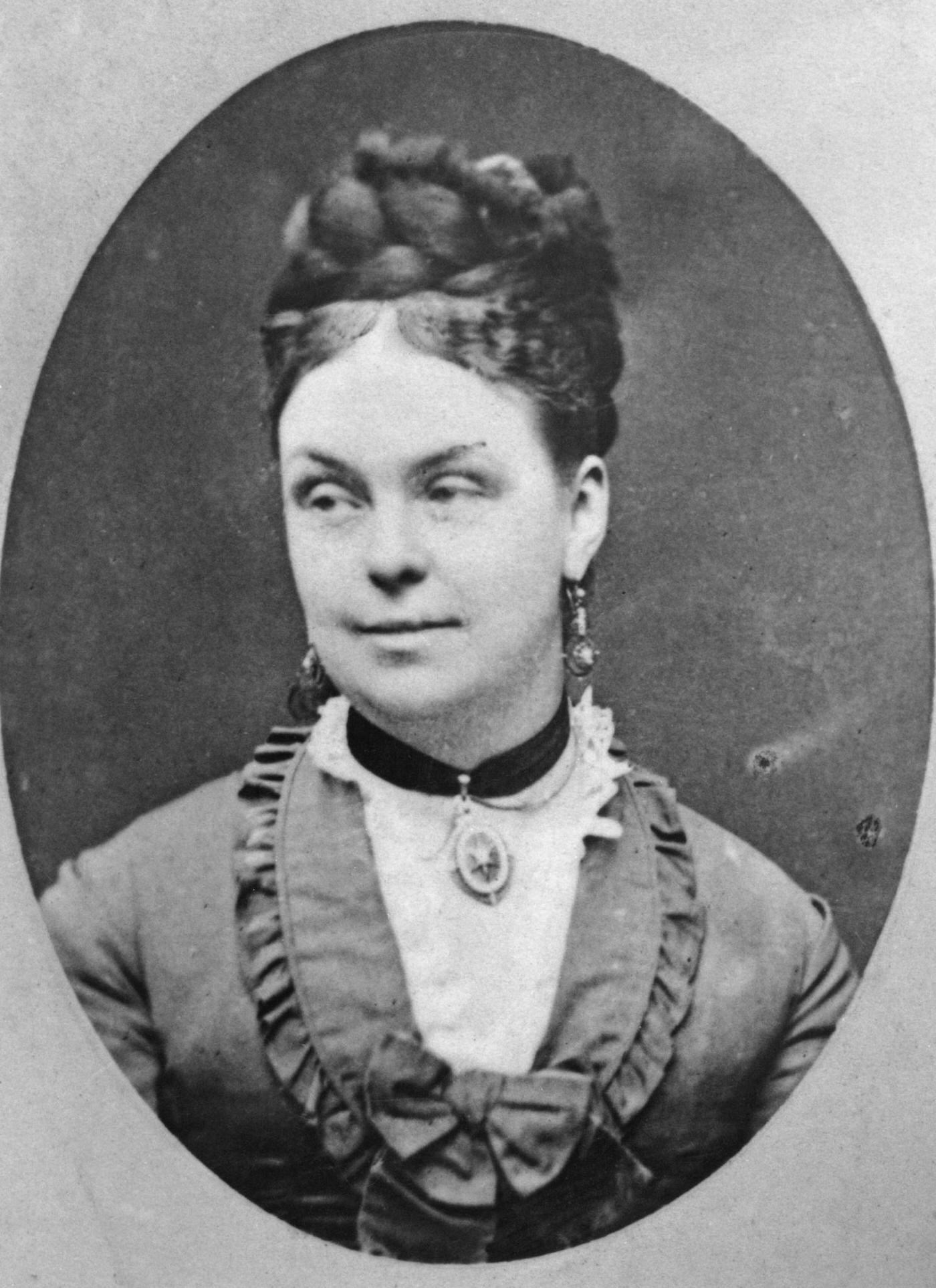 #8 A woman with her hair braided and piled on top of her head, 1870.
