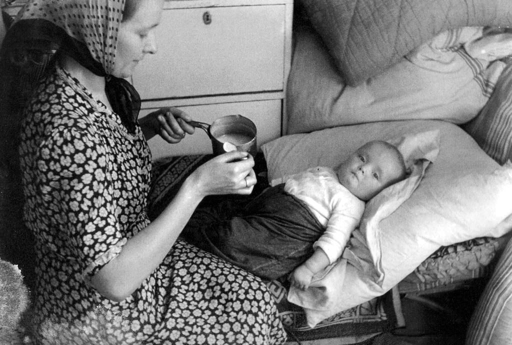 #32 A mother feeding her young daughter in a building on Sienna Street.