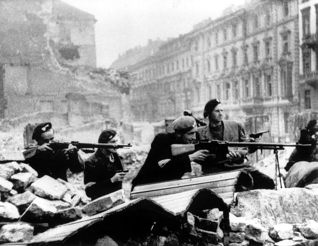 #37 Polish partisans in position behind a barricade on Mazowiecka Street.