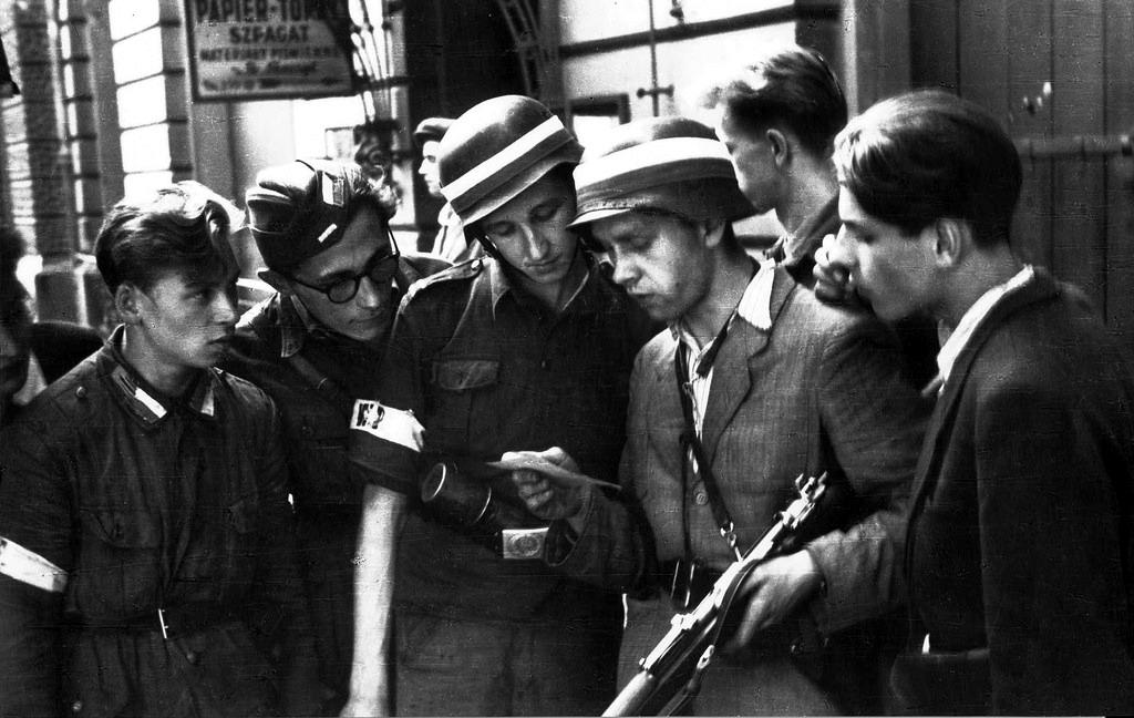 #42 Polish partisans reading a German propaganda leaflet urging them to surrender.