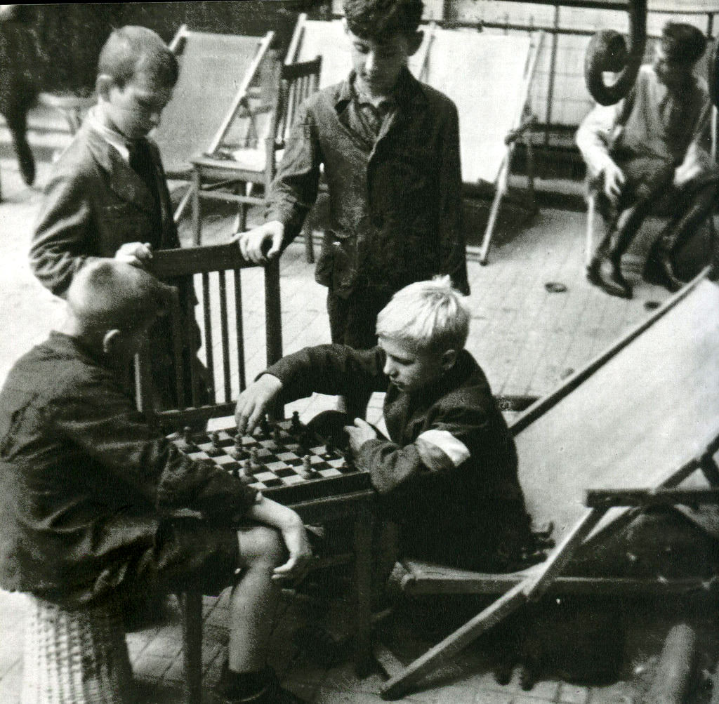 #52 Young insurgents playing chess on streets.