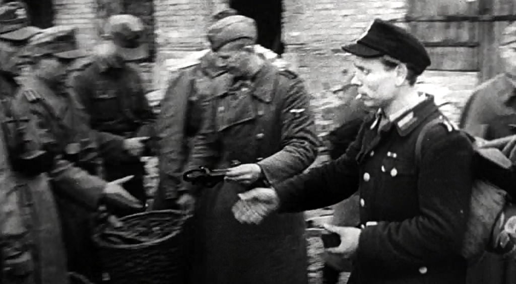 #53 A Polish partisan surrendering his gun.