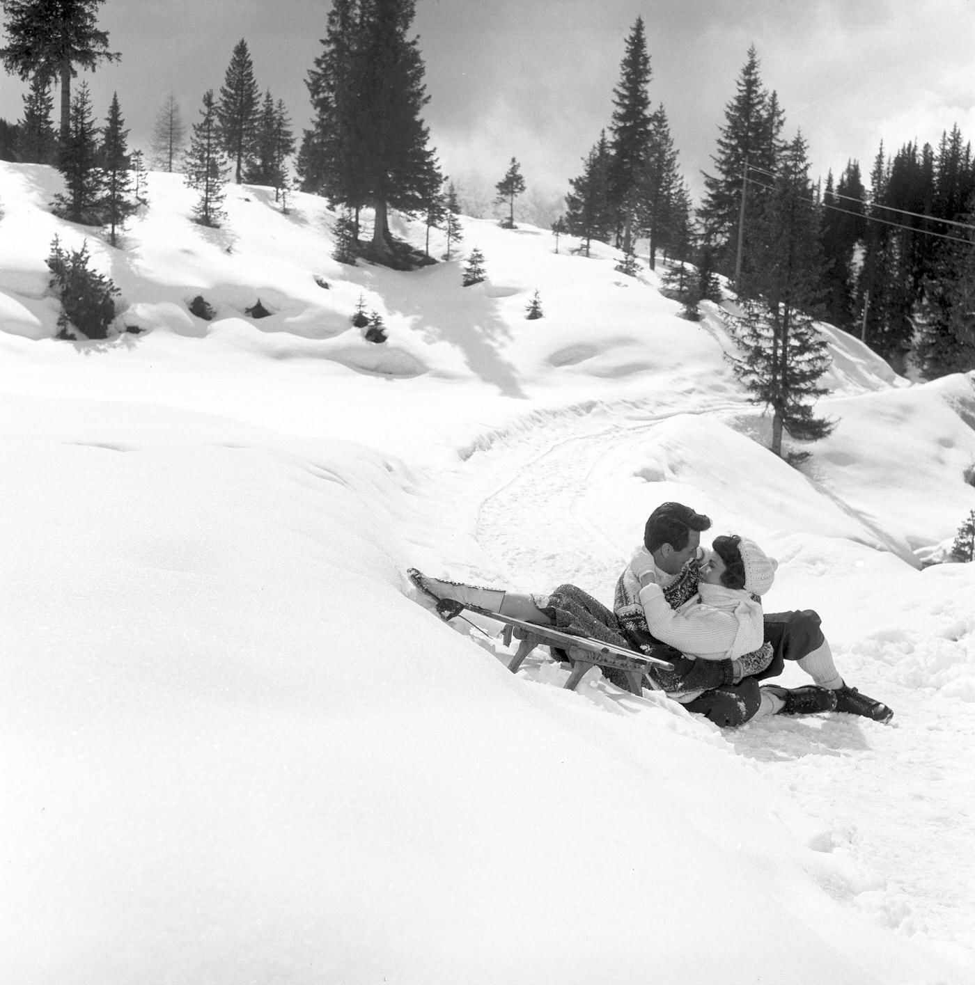 #31 American actor Rock Hudson (Roy Harold Scherer Jr) and American actress Jennifer Jones (Phylis Lee Isley) hugging each other on the snow in a scene from the film A farewell to arms. Italy, 1957