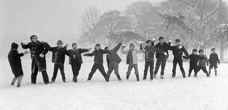 #24 Children on holiday from school throwing snowballs on Tooting Bec Common, 1962.