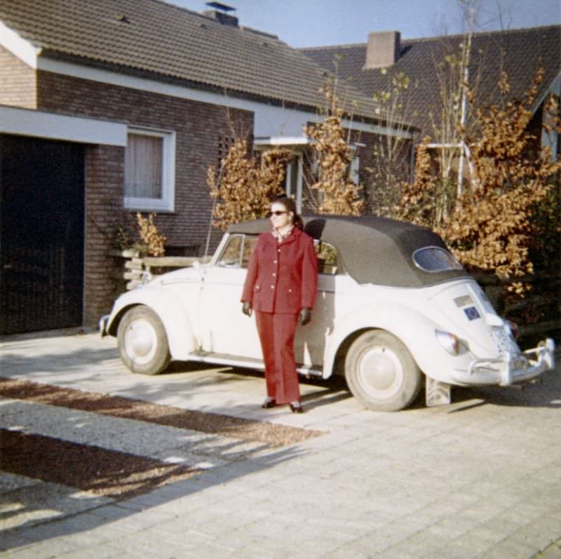 A lady posing with a VW 1200 Cabriolet in front of a middle-class home on a sunny autumn’s day. The print is dated “1968” on reverse, the car is registered in the West German city of Münster