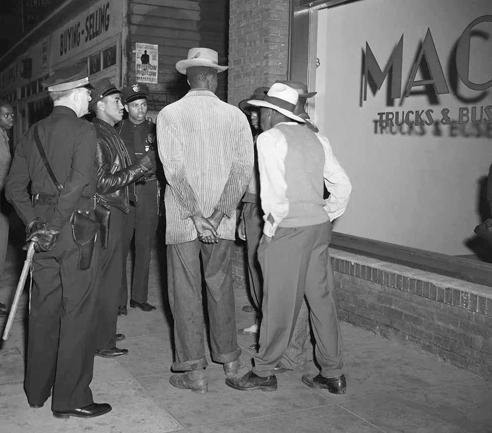#18 Los Angeles policemen examine draft credentials, as they continue the roundup of zoot suit suspects in the aftermath of the rioting.