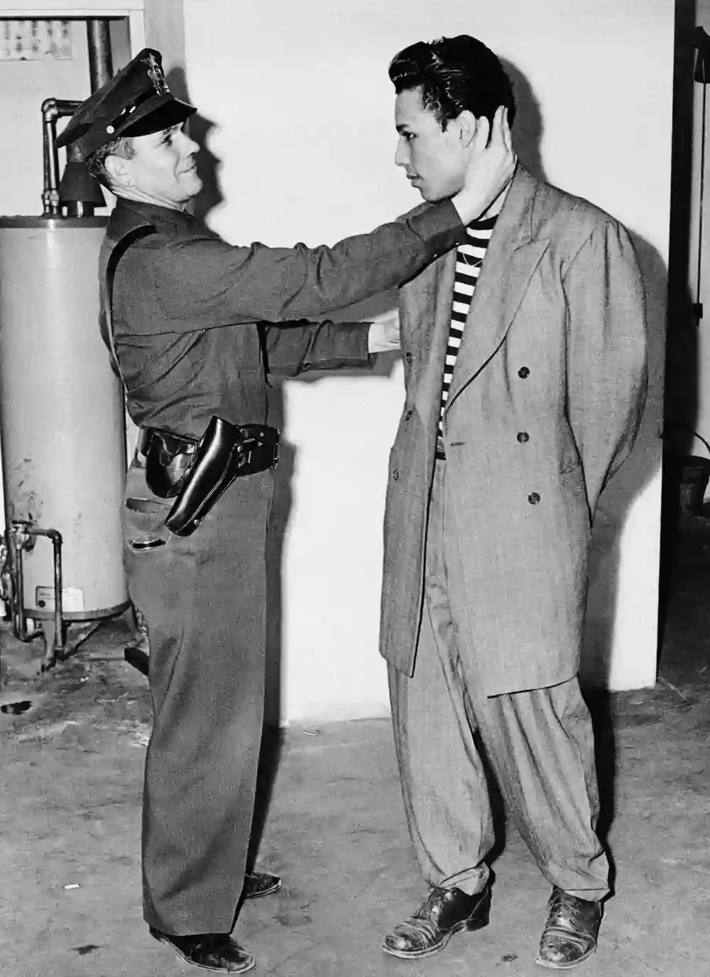 #7 A man in a zoot suit is inspected upon arrest by LAPD on June 7, 1943.