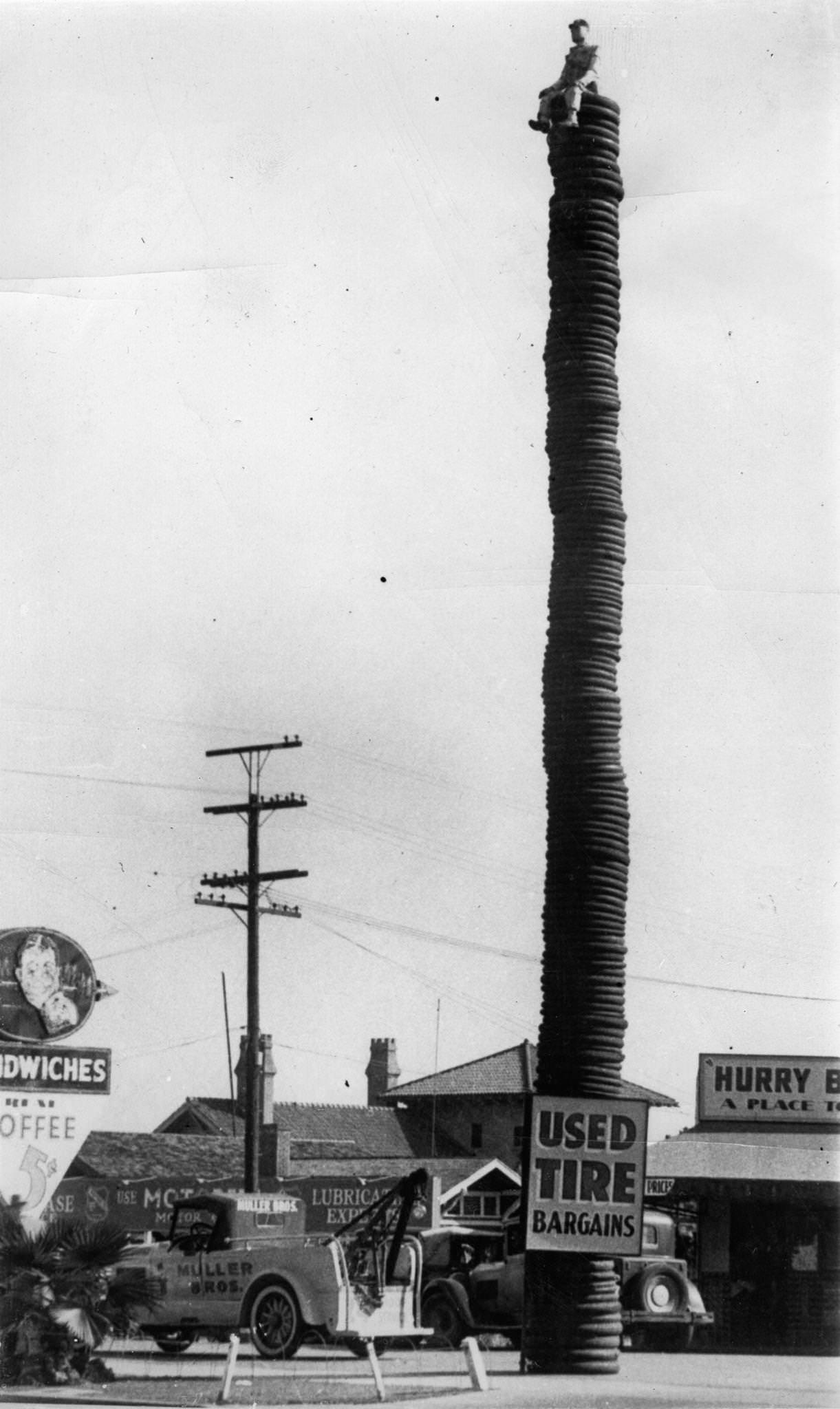 #109 A record breaking stack of tires is used as advertisement at Hollywood, California. To attract attention to a large stock of used tires two salesmen put a lifelike dummy sitting on the top. 2044