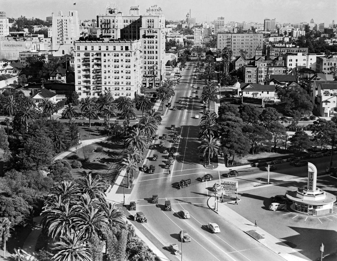 #94 Looking east on Wilshire Blvd at Hoover St with Simon’s Drive-In in the lower right and the Arcady Hotel a couple of blocks up on the left, Los Angeles, 1939.