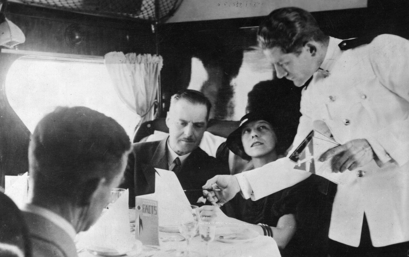 A waiter serves passengers aboard the Imperial Airways ‘Scylla’ flight from London to Paris.