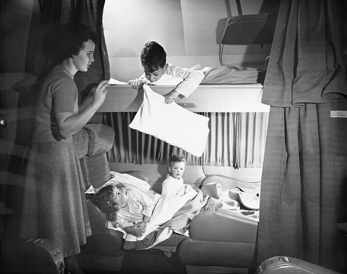 In 1949, a mother is pictured tucking in her children in bunks aboard a Pan American Airways’ Boeing 377 Stratocruiser.