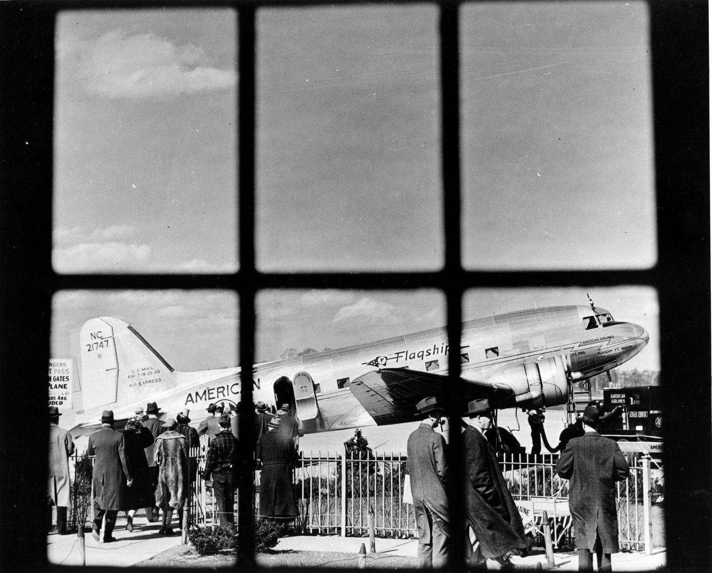 Through a window of the terminal at LaGuardia Airport, passengers are boarding an American Airlines’ ‘Flagship’ plane on the tarmac in 1946.