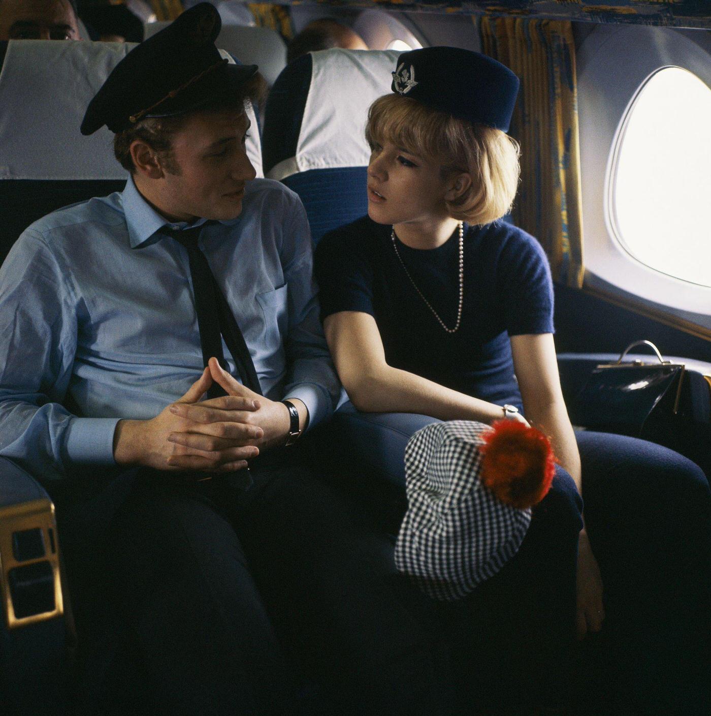 Sylvie Vartan and Johnny Hallyday in an airplane in 1963, with Vartan wearing a flight attendant’s hat and Hallyday wearing a pilot’s cap.