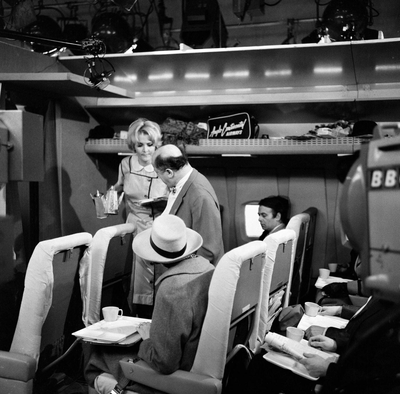 #30 Sheila Hancock playing the role of an air hostess in scenes being shot for the comedy series “The Bed-Sit Girl” at BBC Studios on February 21, 1965.