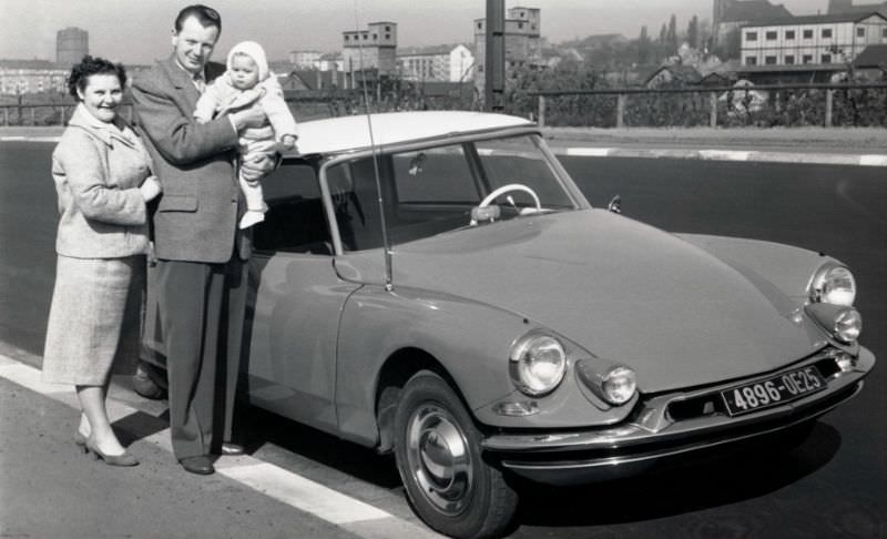 Family of three with Citroën DS on roadside, Saarbrücken plates, 1956