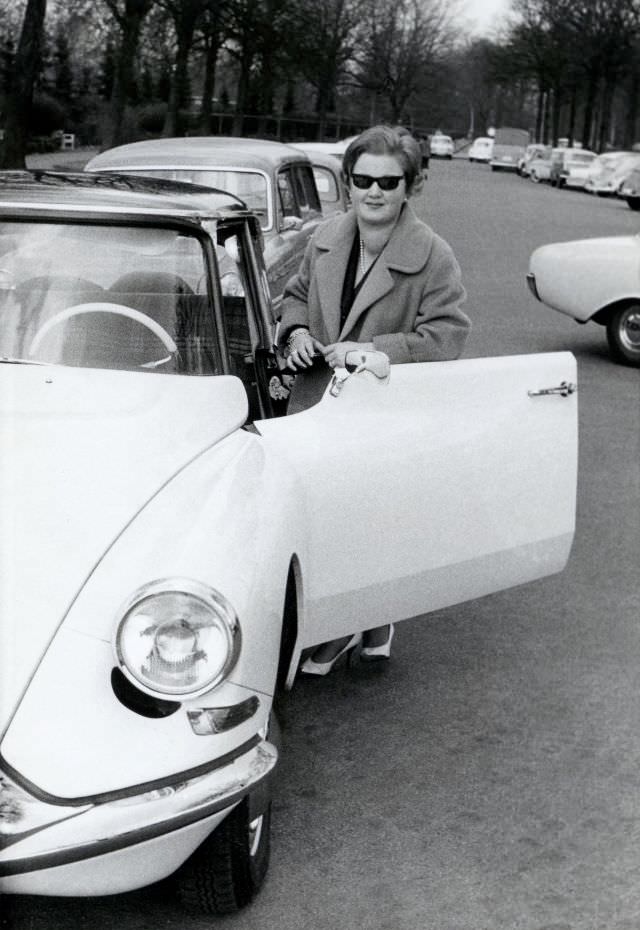 Stylish lady with Citroën DS in busy city street in wintertime, 1962