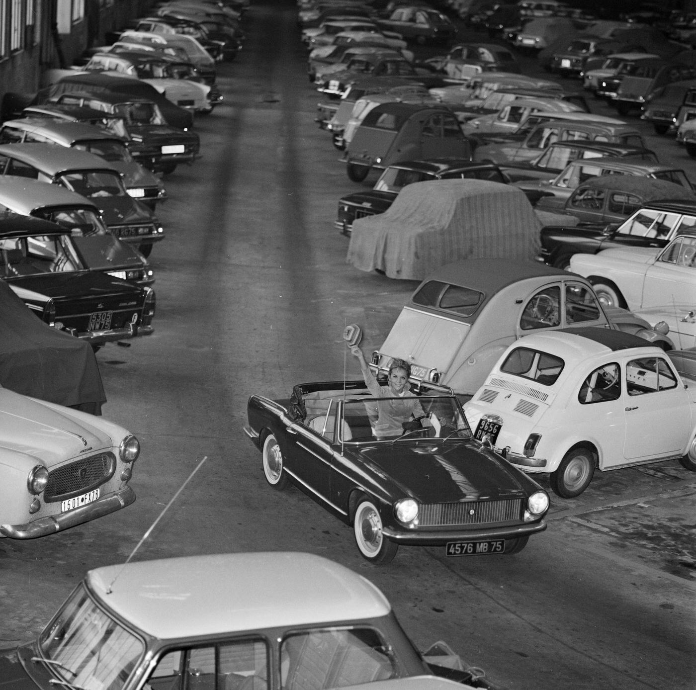 French actress Caroline Cellier posing with her father’s convertible Citroën and waving a bonnet, 1966.