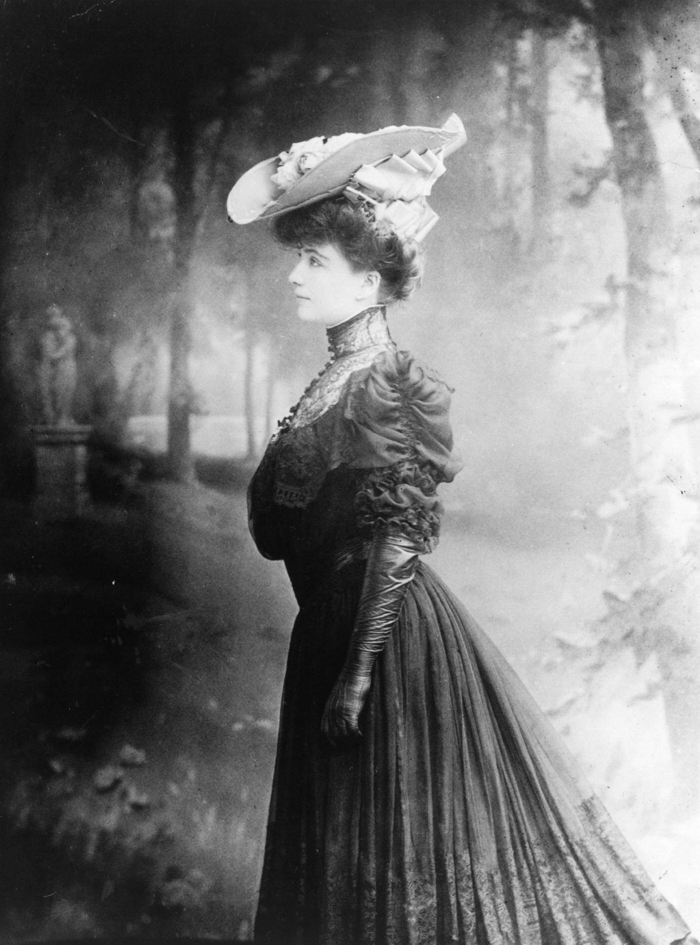 #49 An Edwardian woman looks stunning in a fashionable outfit against the backdrop of woodlands in 1905