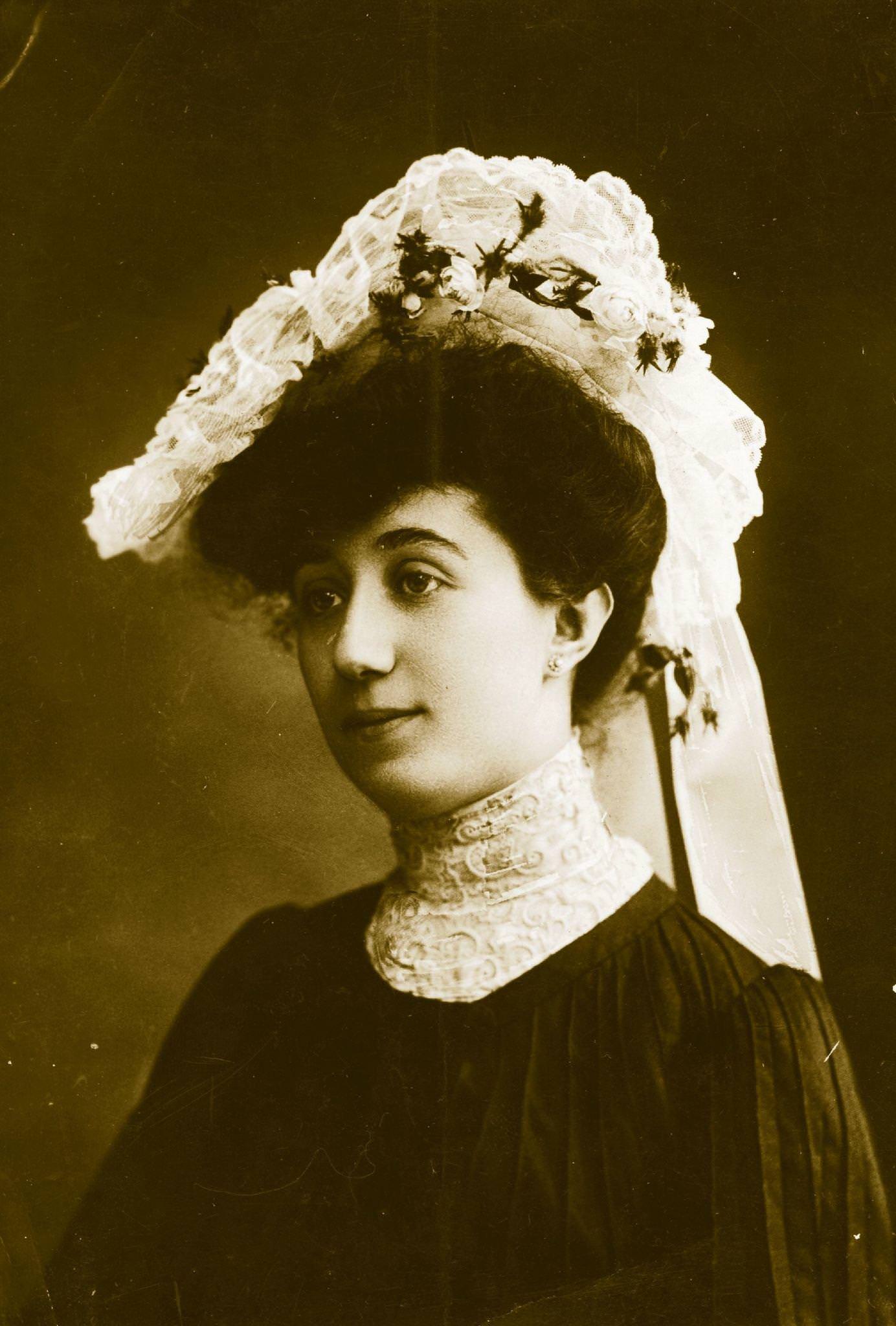 #51 An Edwardian lady wears a high-necked blouse and hat with lace and flower trimmings