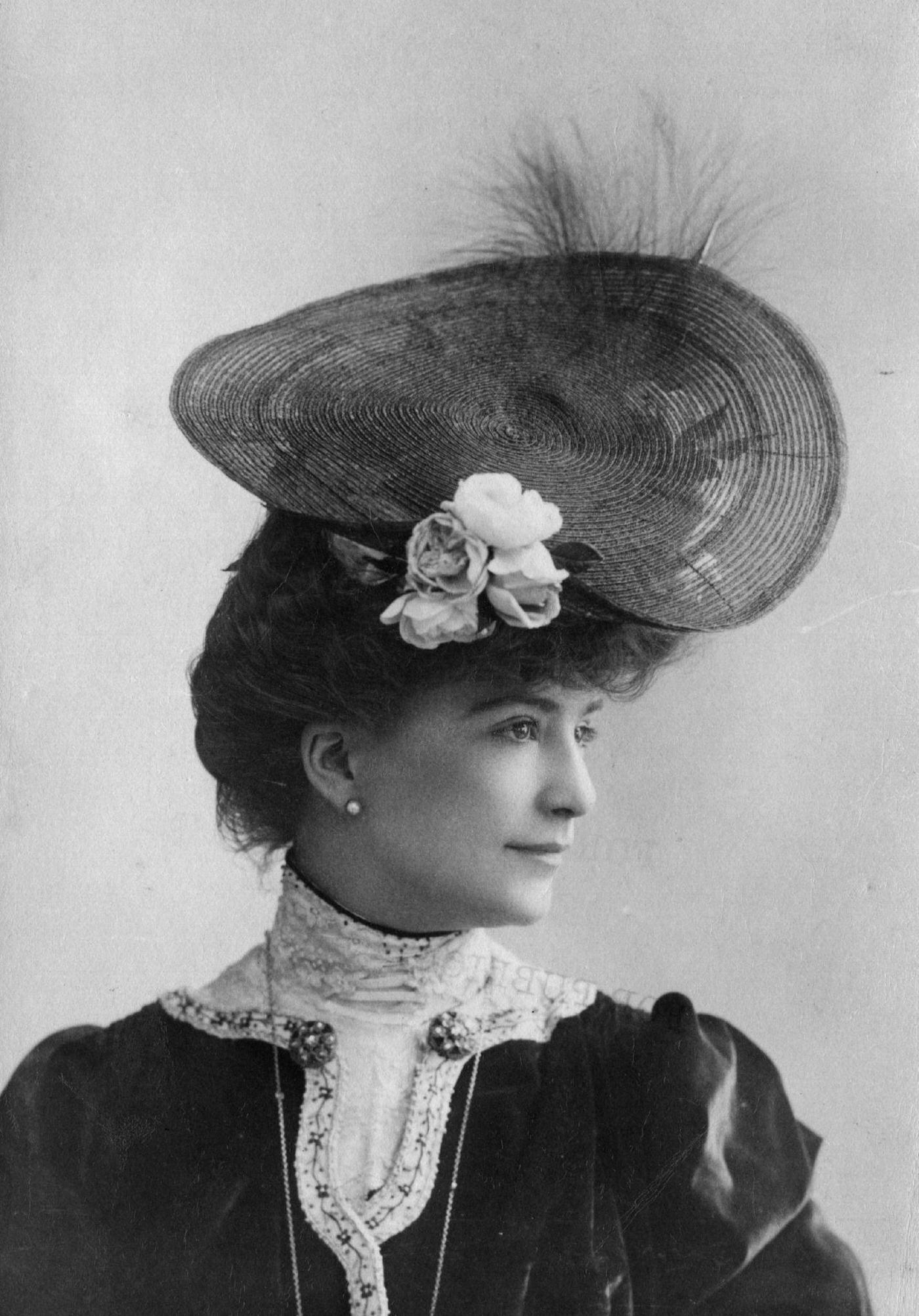 #56 An Edwardian woman wears a circular hat with flower and feather trimming in 1903