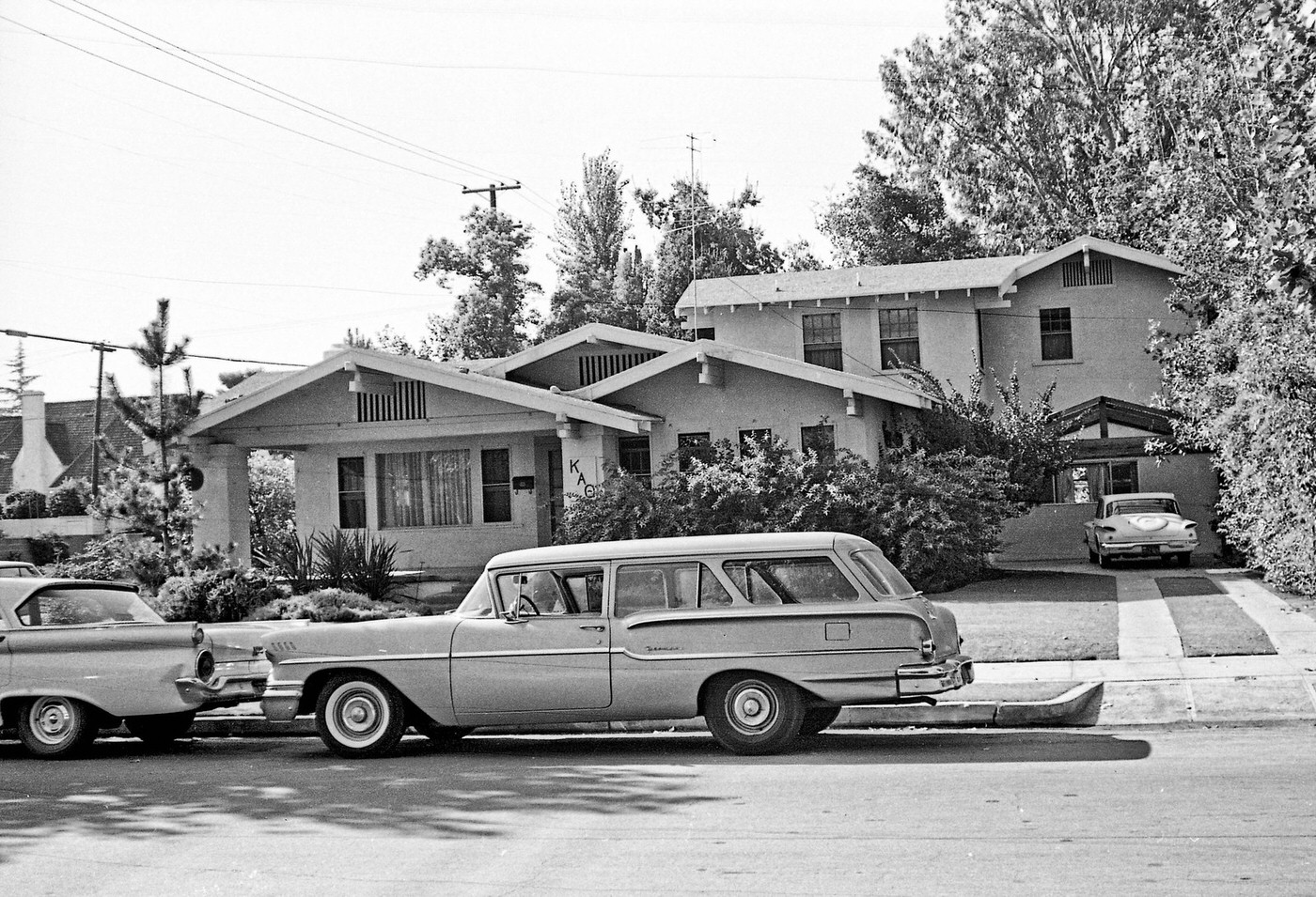 #6 A 1958 Chevy parked on street behind a 1959 Ford in front of the Kappa Alpha Theta sorority house in the older part of Fresno near Fresno City College.