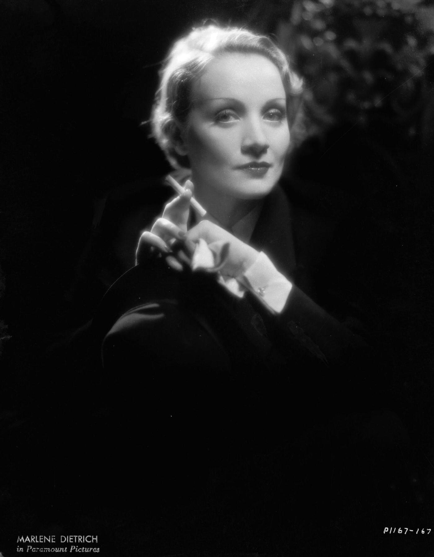 #54 A photograph of Marlene Dietrich smoking.