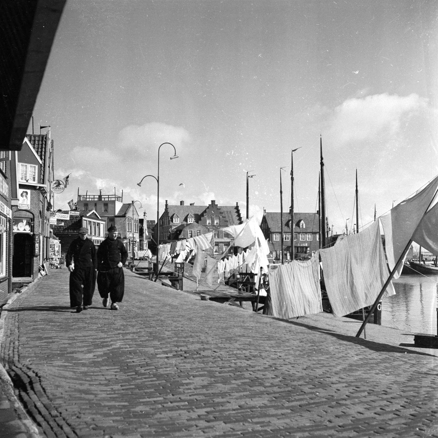 #19 Two men in traditional baggy trousers walking through Volendam harbour in the western Netherlands, 1955.
