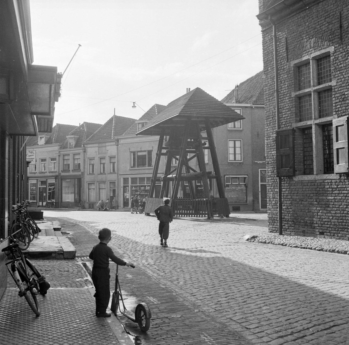 #32 Child of the Haanapel family holds his scooter and watches the street in Doesburg, Netherlands, 16th May 1953.