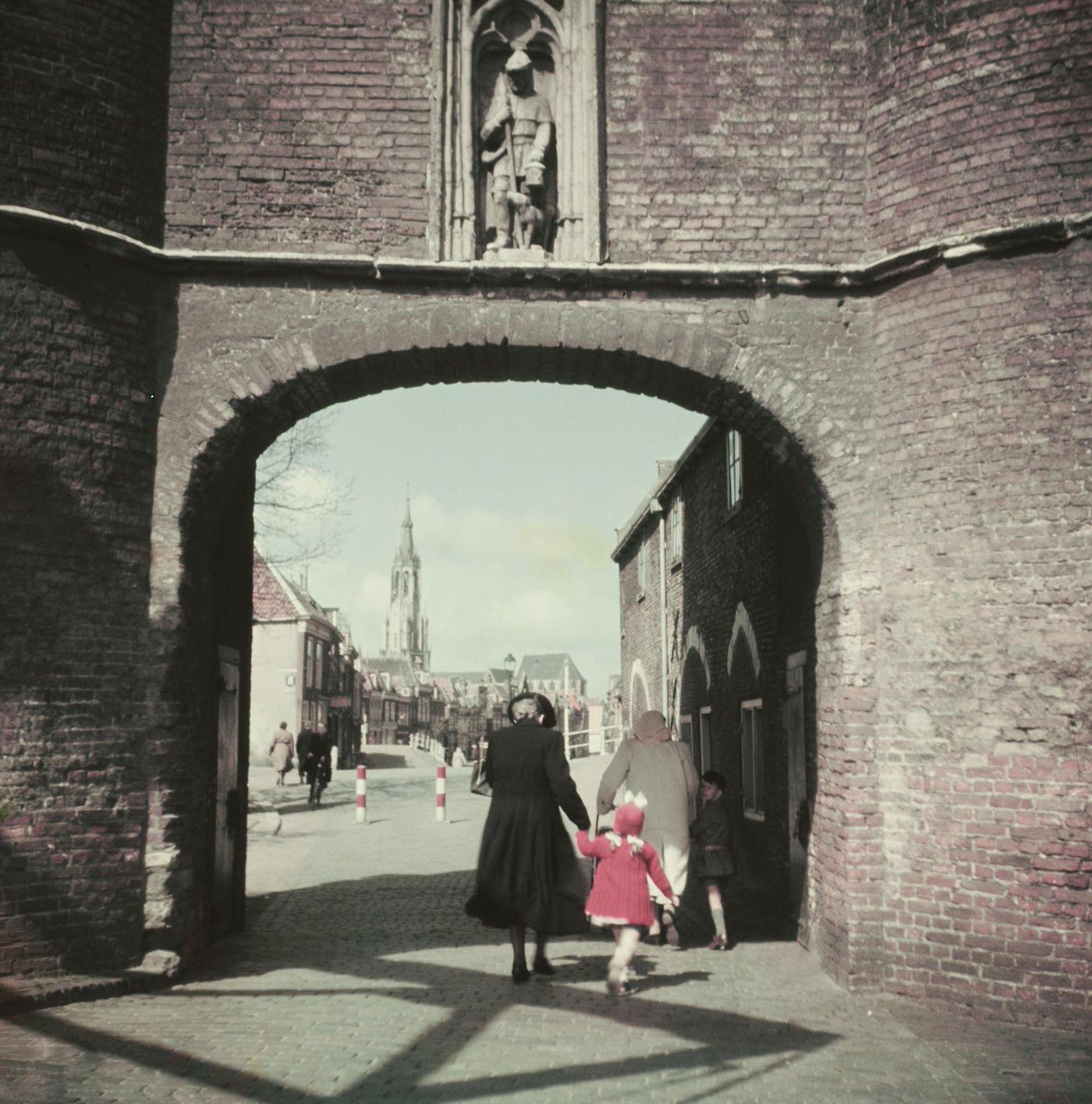 #45 Pedestrians walk through an archway in the center of the city of Delft in the province of South Holland in the Netherlands, 1950.