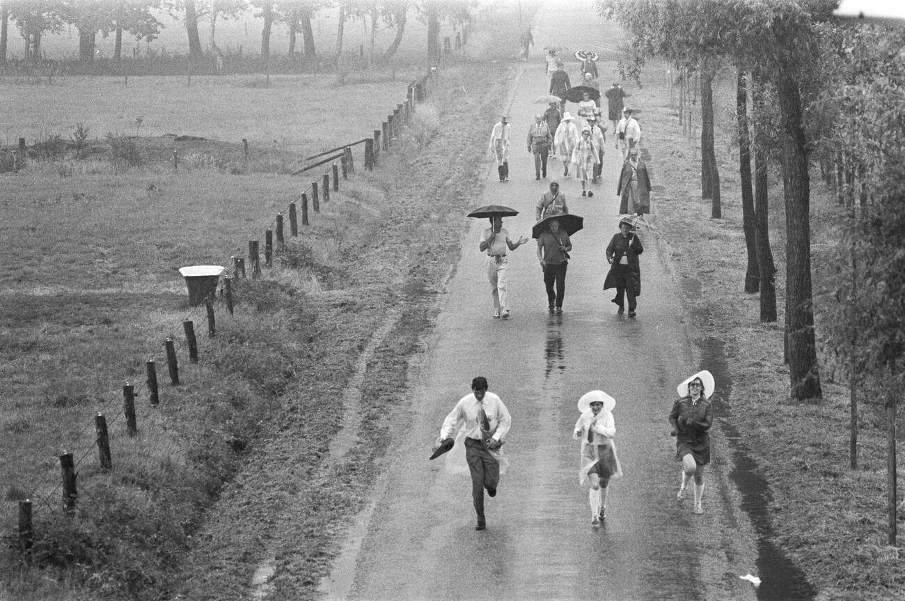 #106 Participants starting the Apeldoorn Four Days Marches in the rain, with an overview on July 13, 1976.