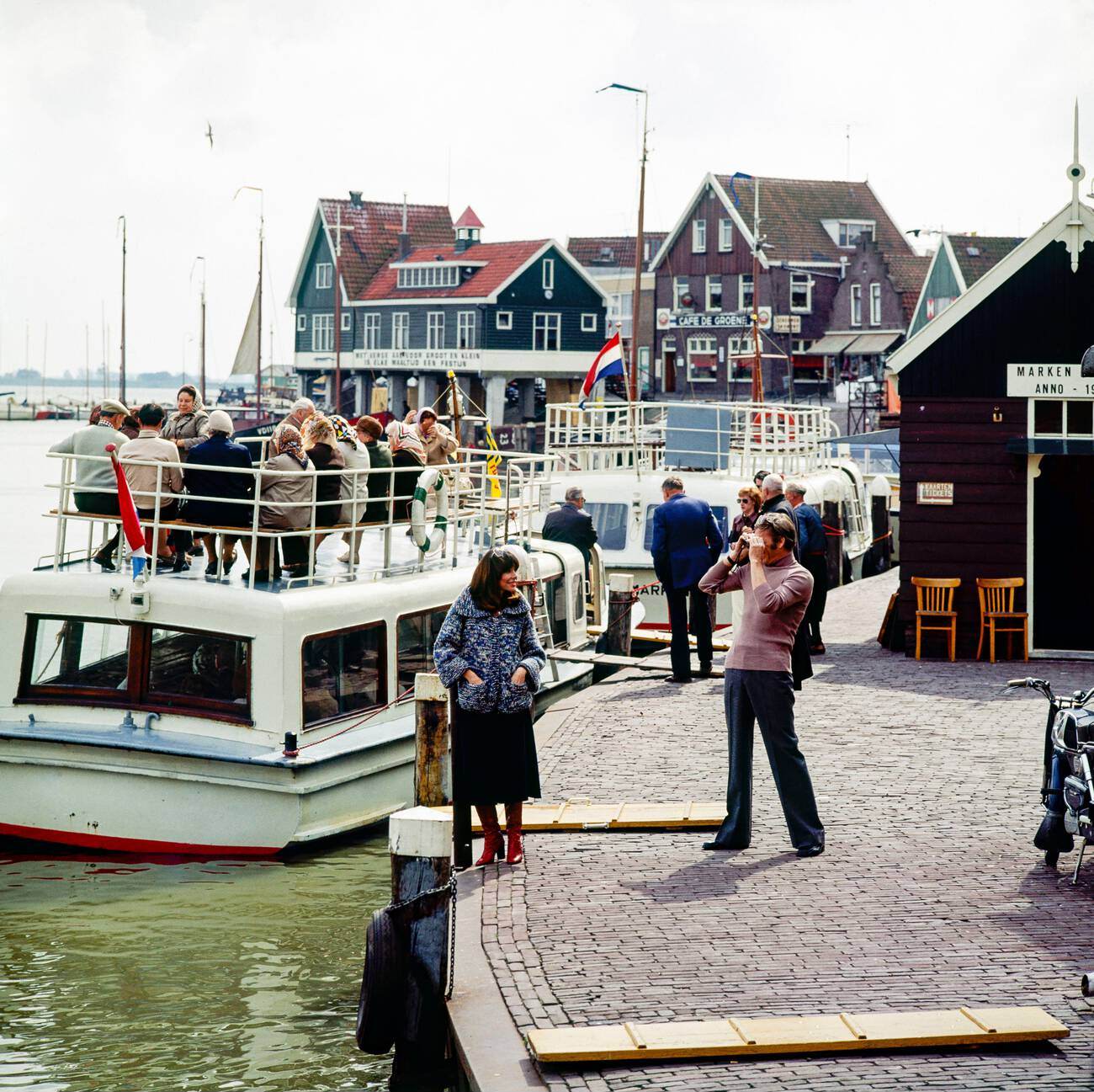 #20 A couple of middle-aged tourists taking pictures at Marken harbor, Waterland, Northern Holland, The Netherlands in the 1970s.