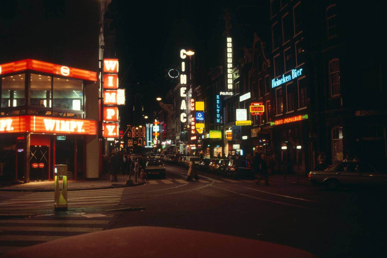 #21 Neon lights at night in the city center of Amsterdam, The Netherlands, during the 1970s-1980s. Wimpy fast food takeaway restaurant is visible.