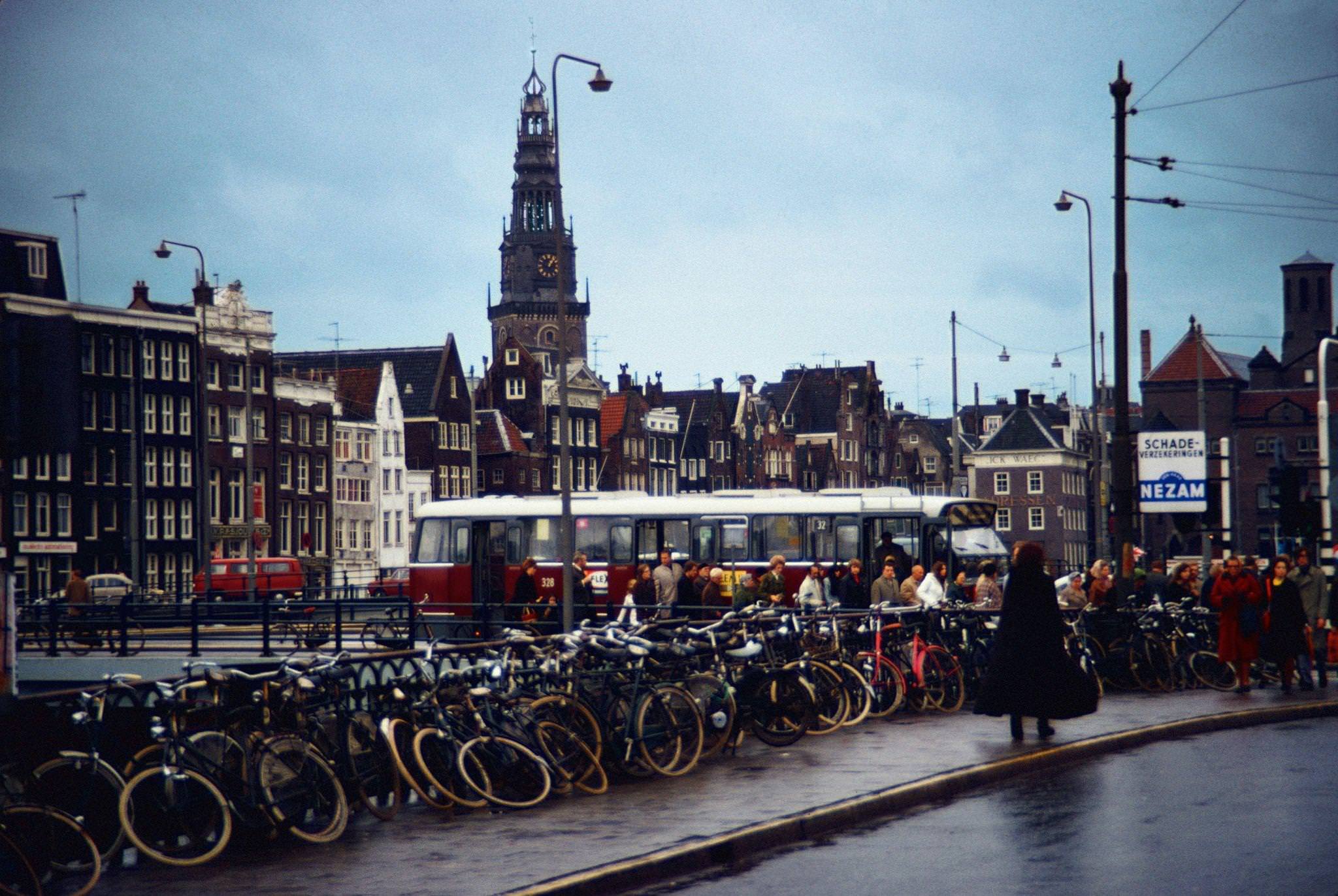 #66 Bicycles on the Damrak in Amsterdam, capital of the Netherlands, with the Oude Kerk in the background – December 1970.